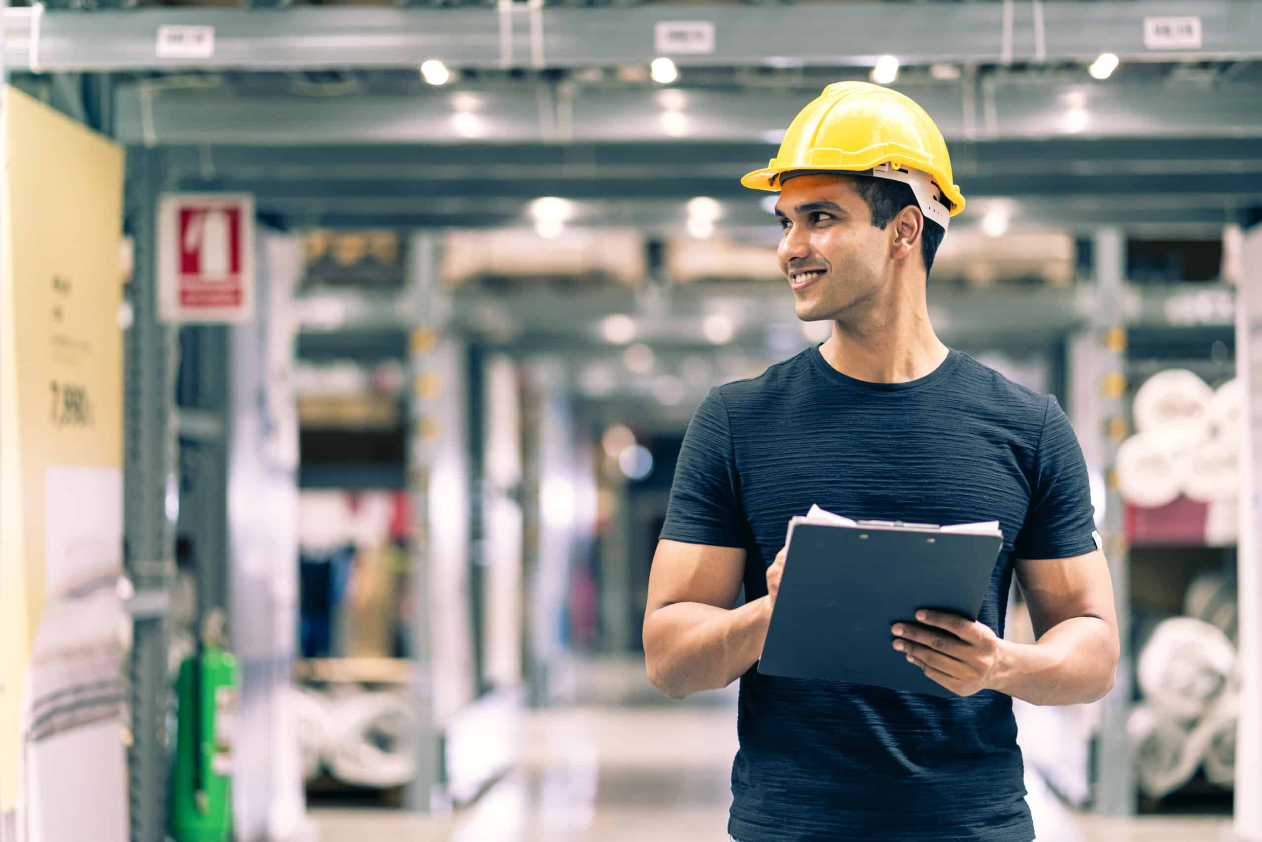 smart indian engineer man wearing safety helmet doing stock tick check cardboard stock product management factory warehouse background scaled